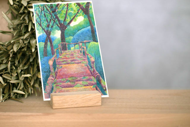 カード類を立てる小型木製スタンドで絵はがきを飾ったイメージ